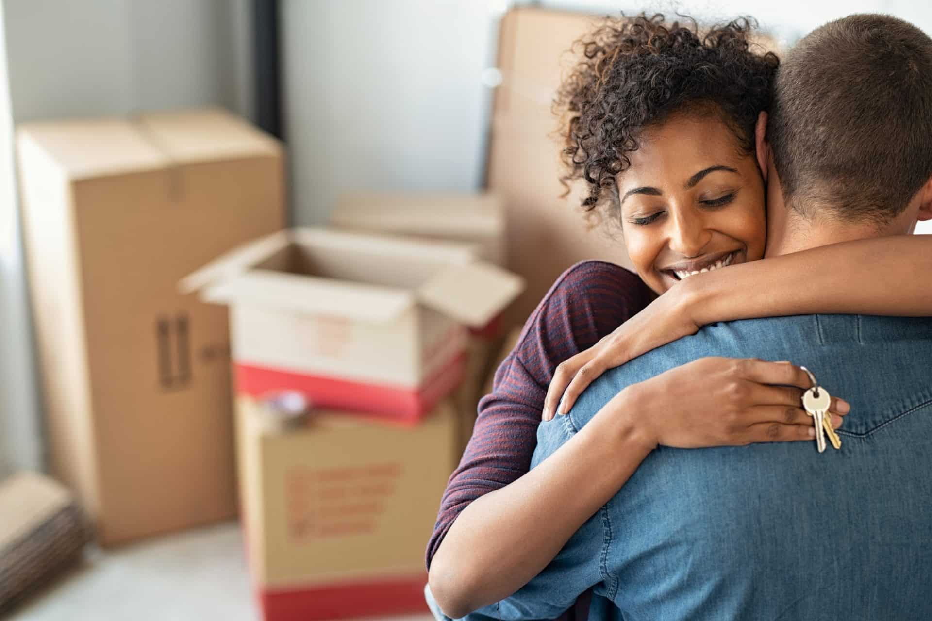 Woman hugging man and holding home keys